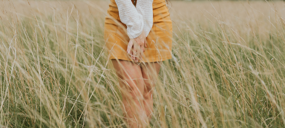 A woman standing in a field cross legged